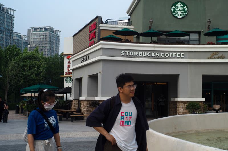 People walk past a Starbucks coffee shop in Beijing