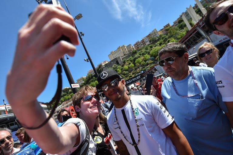 Mercedes AMG Petronas F1 Team's British driver Lewis Hamilton (C) poses for a picture with a supporter ahead of the Monaco Formula One Grand Prix in Monte Carlo on May 22, 2015