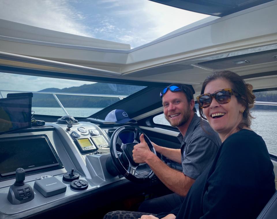 Two people happily take a picture while driving a boat.