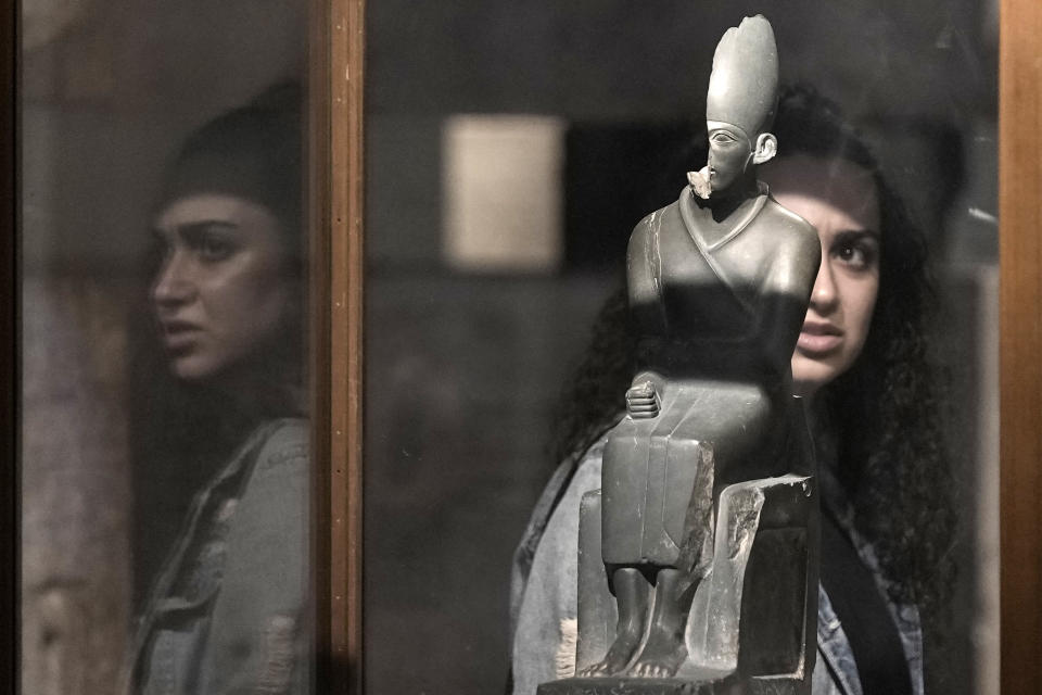 A Toursit watches the seated statue of king Khasekhemwy, last king of the 2nd Dynasty of Egypt, at the Egyptian Museum in Cairo, Egypt, Wednesday, Sept. 27, 2023. Egypt is aiming at reaching 30 million visitors by 2028, as its once-thriving tourism sector has begun to recover from the fallout of the coronavirus pandemic and the grinding war in Europe, Egypt's Tourism and Antiquities Minister Ahmed Issa said during an interview with the Associated Press. (AP Photo/Amr Nabil)