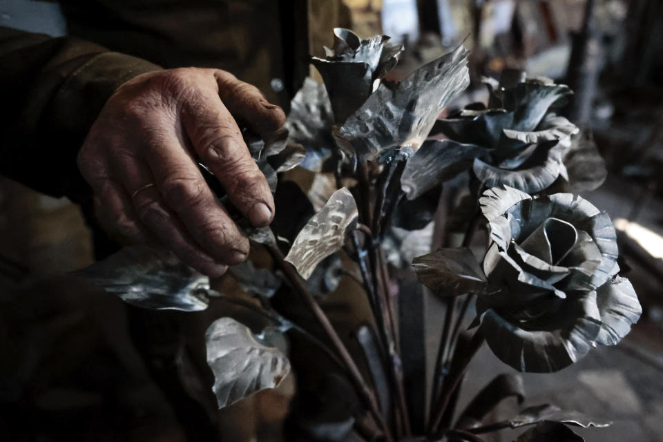 A bunch of roses transformed from weapons and ammunition into flowers of war by hands of Viktor Mikhalev are on display in a workshop in his house in a workshop in his house in Donetsk, Russian-controlled Donetsk region, eastern Ukraine, Saturday, March 4, 2023. Mikhalev, trained as a welder, lives and works in a house whose fence and door are decorated with forged flowers and grapes. (AP Photo/Alexei Alexandrov)