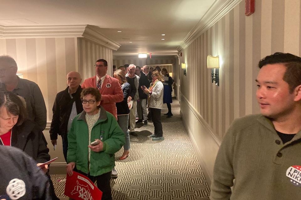 A line of people inside a hotel.