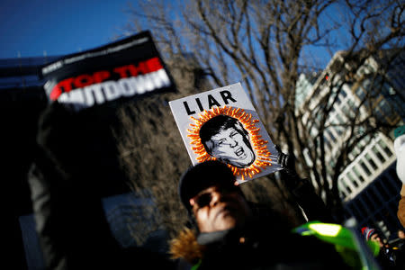 Demonstrators carry signs during a “Rally to End the Shutdown” in Washington, U.S., January 10, 2019. REUTERS/Carlos Barria