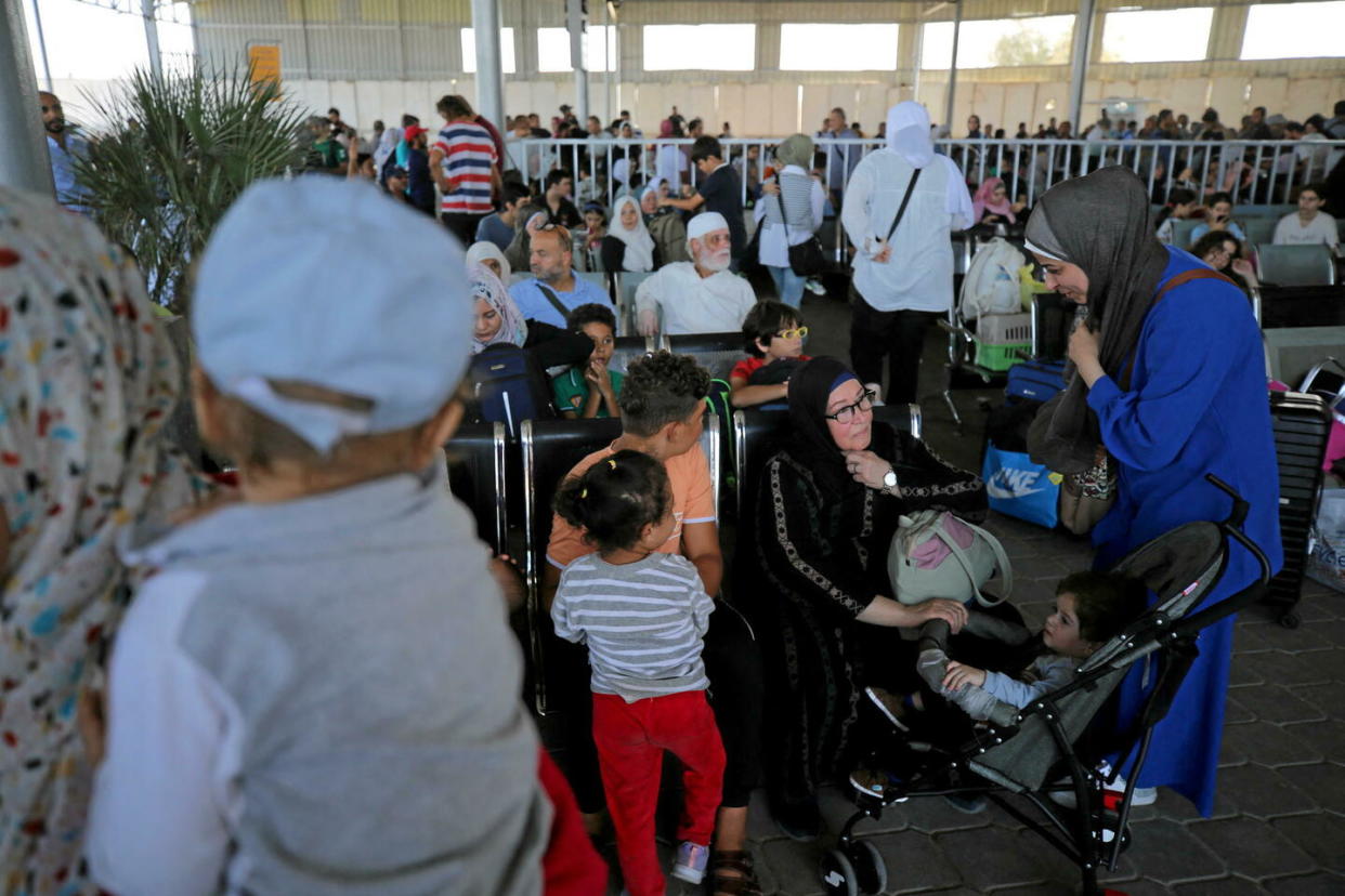 Des personnes sont assises dans la zone d'attente du poste frontière de Rafah, dans le sud de la bande de Gaza, avant de passer en Égypte, le 1er novembre 2023.  - Credit:MAJDI FATHI / NurPhoto / NurPhoto via AFP