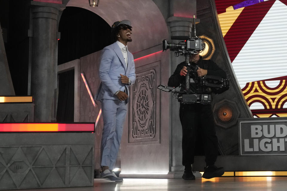 LSU quarterback Jayden Daniels celebrates after being chosen by the Washington Commanders with the second overall pick during the first round of the NFL football draft, Thursday, April 25, 2024, in Detroit. (AP Photo/Jeff Roberson)