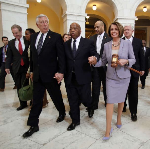 PHOTO: House Speaker Nancy Pelosi holds a large gavel as she walks through the Cannon Rotunda after a Democratic Caucus, along with from left, are Reps. Steny Hoyer, John Lewis, and John Larson, March 21, 2010 on Capitol Hill in Washington. (Lauren Victoria Burke/AP, FILE)