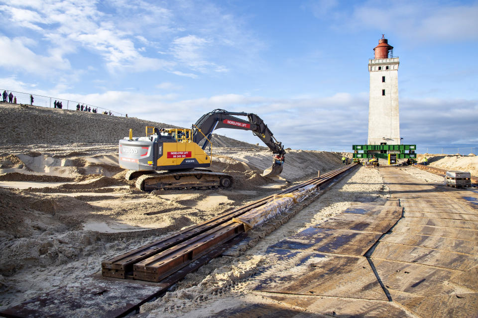 In this photo taken on Monday, Oct. 21, 2019, preparations are being made to move the Rubjerg Knude Lighthouse in Jutland, Denmark. A 120-year-old lighthouse has been put on wheels and rails to attempt to move it some 80 meters (263 feet) away from the North Sea, which has been eroding the coastline of northwestern Denmark. When the 23-meter (76 feet) tall Rubjerg Knude lighthouse was first lit, in 1990, it was roughly 200 meters (656 feet) from the coast; now it is only about 6 meters away. (Henning Bagger/Ritzau Scanpix via AP)