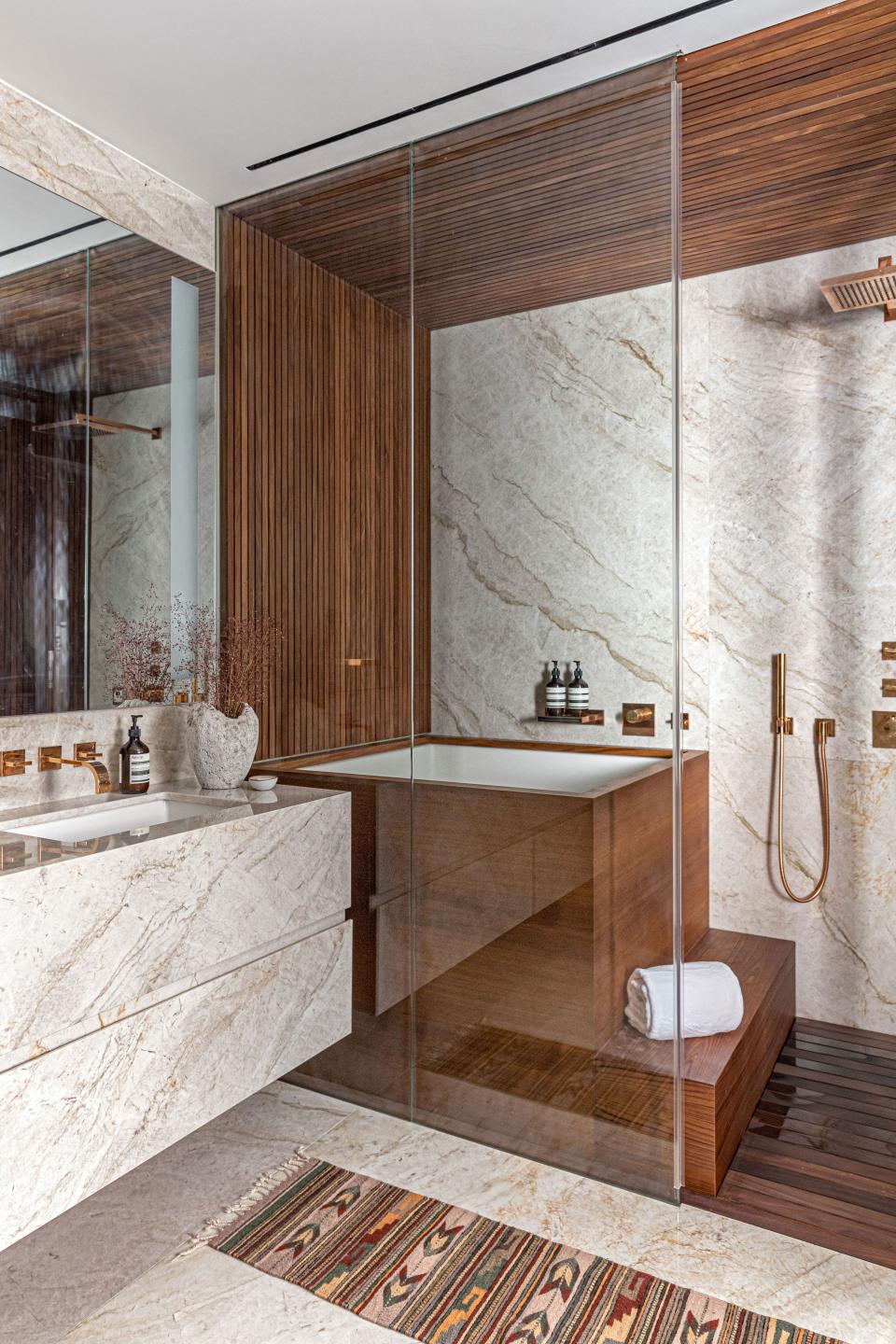 Glass, marble, and teak are the only materials used in the primary bath, which features a massive shower and soaking tub. As for the fixtures, Shea strayed outside of her comfort zone and went with rose gold. “It counteracts with the marble in such a beautiful way,” she says.