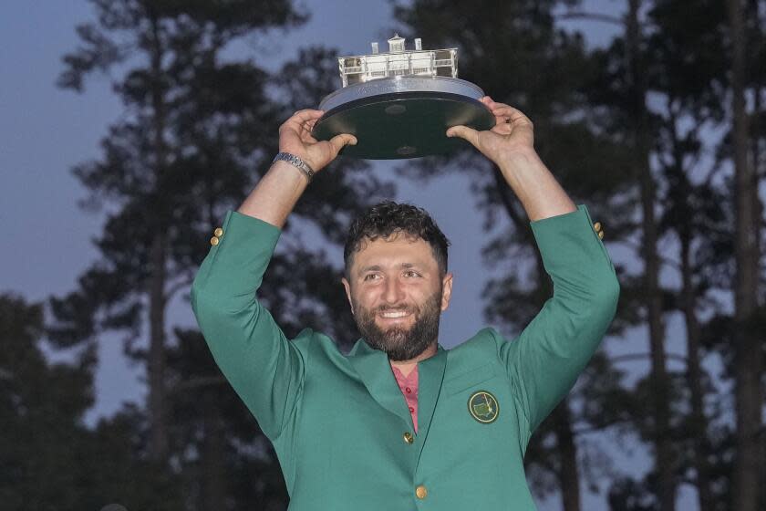 Jon Rahm holds up the trophy after winning the Masters golf tournament at Augusta National Golf Club.