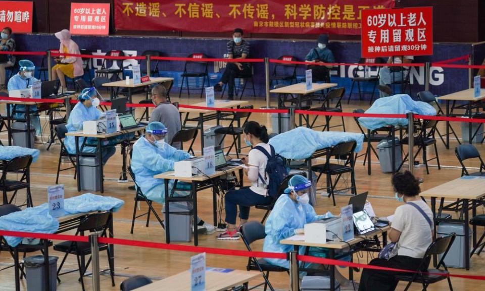 Residents register before getting inoculated against the COVID-19 virus at a vaccination site in a stadium in Nanjing, capital of east China’s Jiangsu Province