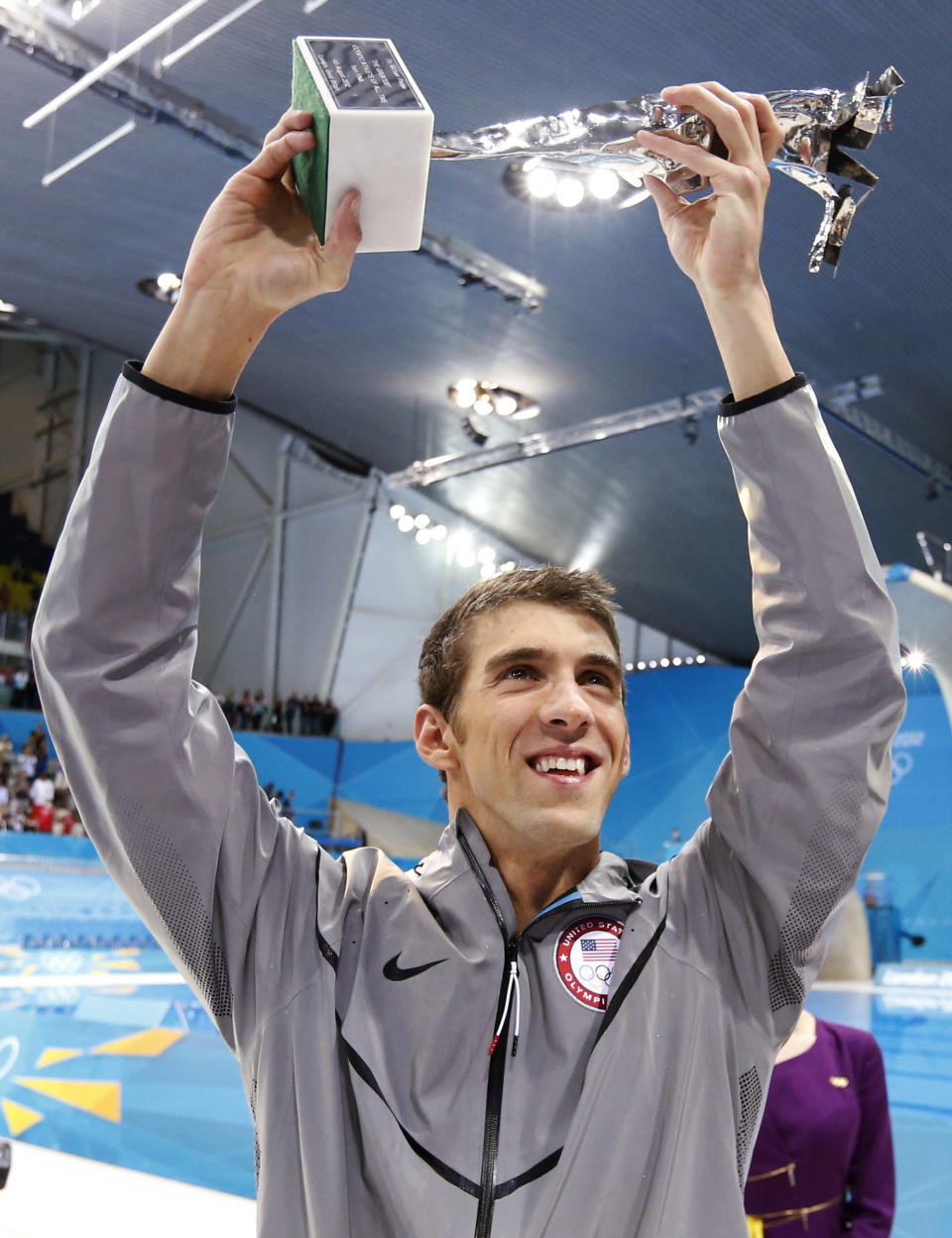 Michael Phelps of the U.S. holds up his trophy awarded to him by FINA honouring him as the most decorated Olympian of all time, after winning the men's 4x100m medley relay final during the London 2012 Olympic Games at the Aquatics Centre August 4, 2012. Phelps ended his incredible Olympic career on the perfect note on Saturday, winning his 18th gold medal for the United States in the men's medley relay, the last time he will swim a competitive race. The trophy reads, "To Michael Phelps, the greatest Olympic athlete of all time, from FINA". REUTERS/Jorge Silva (BRITAIN - Tags: SPORT SWIMMING OLYMPICS) 