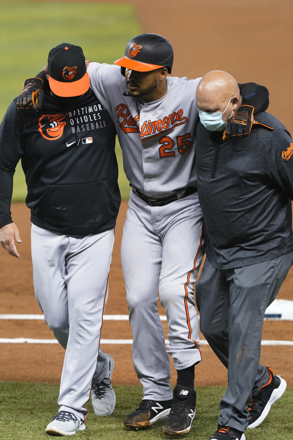 Baltimore Orioles' Anthony Santander (25) is assisted off the field after he was injured during the first inning of a baseball game against the Miami Marlins, Tuesday, April 20, 2021, in Miami. (AP Photo/Marta Lavandier)