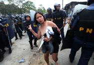 epa04044215 A Filipino informal settler runs half naked in front of policemen during a demolition of shanties at Sitio San Roque in Quezon City, east of Manila, Philippines, 27 January 2014. Throwing rocks, pillboxes, and even human waste, illegal settlers barricaded the demolition team in Baranggay Bagong Pag-asa. Four residents were arrested and twelve were reported injured. Residents report receiving cash from 300 to 450 US dollar in exchange for their voluntary relocation. Earlier, hundreds of the urban poor marched to the city hall in protest of the demolition that will pave the way for the rise of a business district. EPA/DENNIS M. SABANGAN