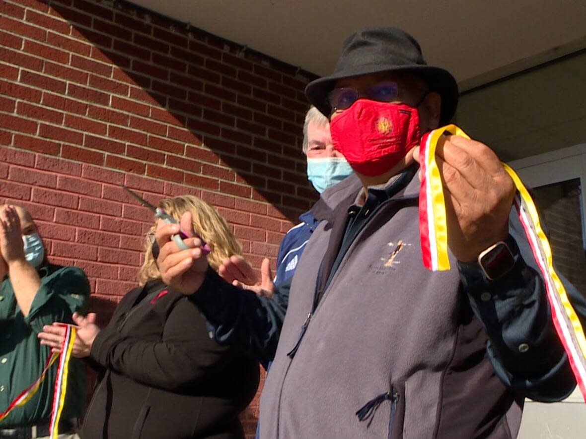 Sagamaw Mi'sel Joe, chief of the Miawpukek First Nation, celebrates the opening of the Ta’n Etl-Mawita’mk Community Centre with a ribbon-cutting.  (Garrett Barry/CBC - image credit)