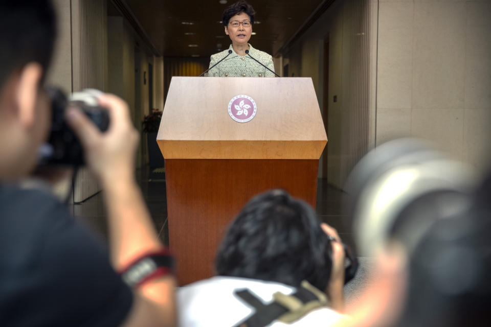 Journalists take photos as Hong Kong Chief Executive Carrie Lam speaks during a press conference at the government building in Hong Kong, Tuesday, Oct. 15, 2019. A homemade, remote-controlled bomb intended to "kill or to harm" riot control officers was detonated as they deployed against renewed violence in Hong Kong over the weekend, police said Monday, in a further escalation of destructive street battles gripping the business hub. (AP Photo/Mark Schiefelbein)