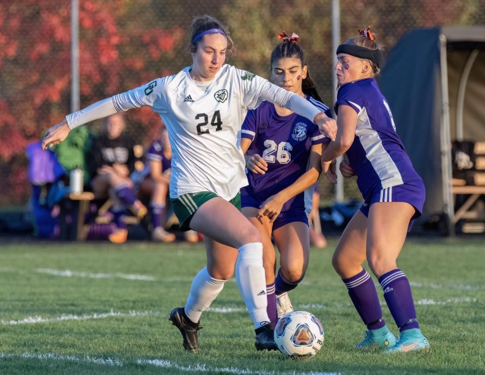 GlenOak’s Emma Pooley takes the ball past Jackson’s Raquel Maghes (26) and Rebekah Yoder on Monday, Oct. 23, 2023.