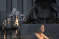 <p>Women are reflected on an advertisement for Apple’s MacBook computer on display near a shopping mall in Beijing, Thursday, September 6, 2018. China’s government says it is ready to retaliate if U.S. President Donald Trump goes ahead with plans for another tariff hike on Chinese goods. The Commerce Ministry expressed confidence it can maintain “steady and healthy” economic growth despite their spiraling trade battle. (AP Photo/Andy Wong) </p>