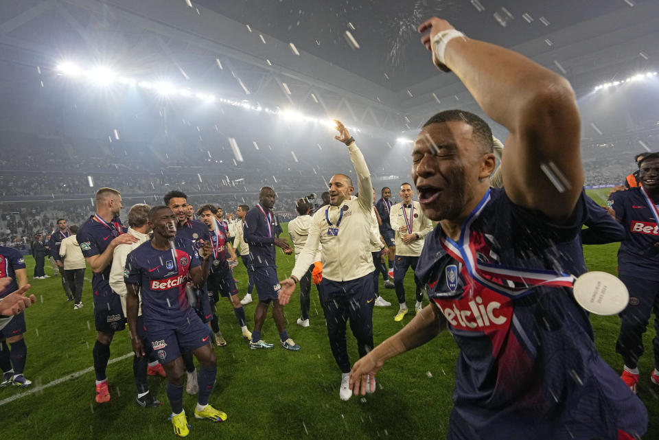 PSG's Kylian Mbappe celebrates after the French Cup final soccer match between Lyon and PSG at the Pierre Mauroy stadium in Villeneuve d'Ascq, northern France, Saturday, May 25, 2024. PSG won the match 2-1. (AP Photo/Michel Euler)