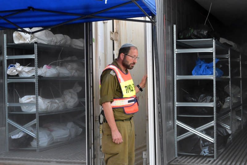 A soldier from the military rabbinate unit stands by containers full of bodies and body parts of people murdered by Hamas near the Gaza border, at the military morgue on the Shura Army Base near Ramla. Identifying hundreds of unidentifiable burned and tortured bodies from the war in Israel has required advanced technology as forensic workers warn “not all bodies will be identified.” Photo by Debbie Hill/UPI