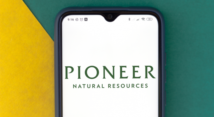 Pioneer Natural Resources Company (PXD) logo seen on a smartphone with a green and yellow background