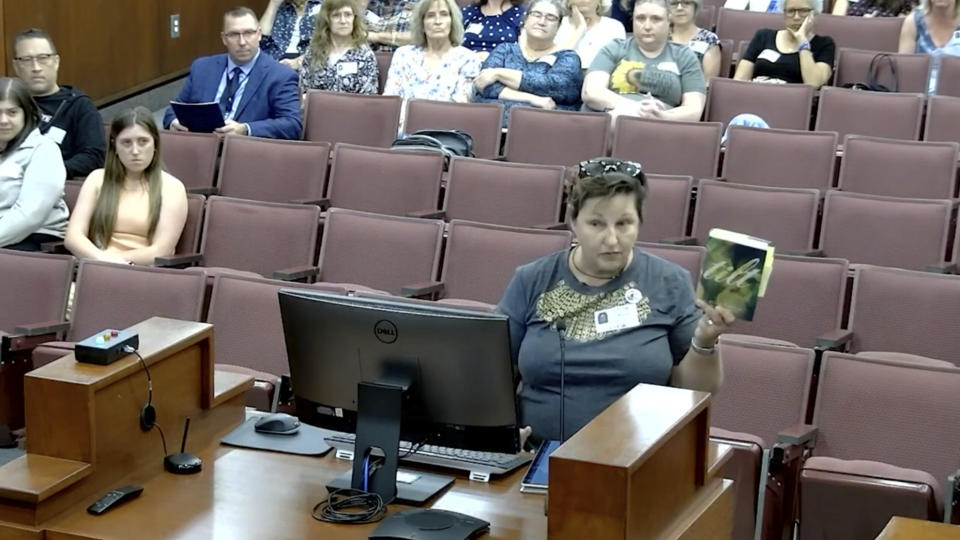 In this image from video posted by the Forsyth County school board, T.J. McKinney, a departing teacher of autistic students at a Forsyth middle school, speaks during a meeting of the board in Cumming, Ga., on June 20, 2023. She said students need to see their own struggles reflected in books, and it's pointless to shield older students from vulgarity or sex. “The book is not introducing kids to sex. If you’re in high school, they’re having sex," McKinney said. “These kids are saying it. They’re doing it. They are not learning this from books." (Forsyth County Schools via AP)