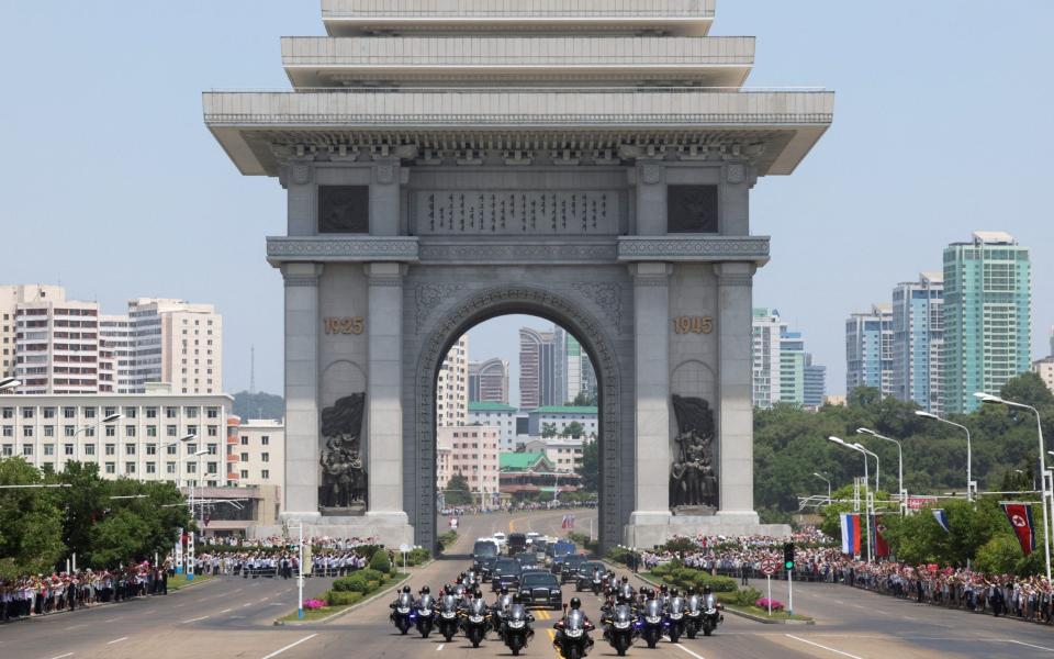 A convoy transports Kim Jong Un and Vladimir Putin through the Arch of Triumph