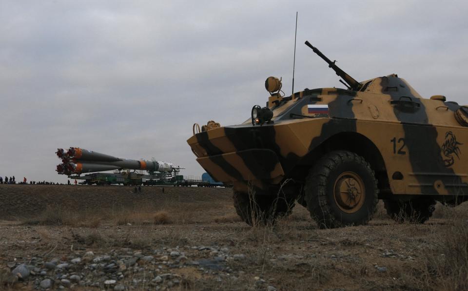 Policemen in an armoured security vehicle guard the Soyuz TMA-12M spacecraftas it is transported to its launch pad at the Baikonur cosmodrome