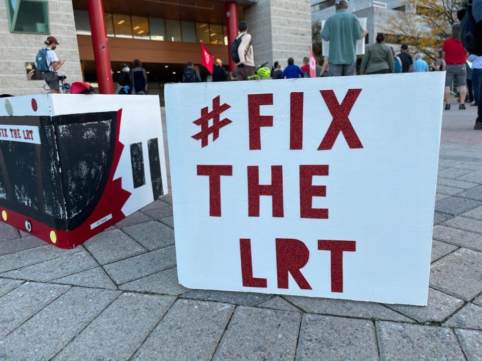 A sign reads 'Fix the LRT' on the steps of Ottawa City Hall during a rally against the city's decisions around its light rail system, which has been out of commission since Sept. 19. (Nicole Williams/CBC - image credit)