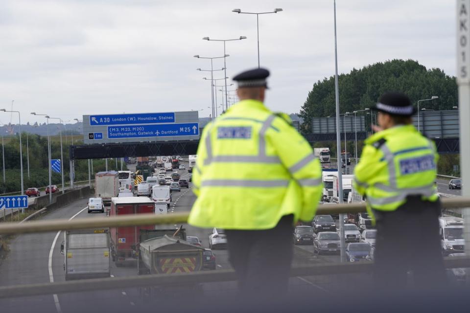 Police officers watch the M25 motorway near Heathrow Airport for Insulate Britain protestors (Steve Parsons/PA) (PA Wire)