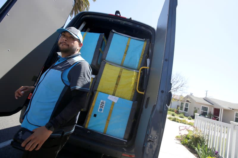 Joseph Alvarado opens the back of the van as he makes deliveries for Amazon during the outbreak of the coronavirus disease