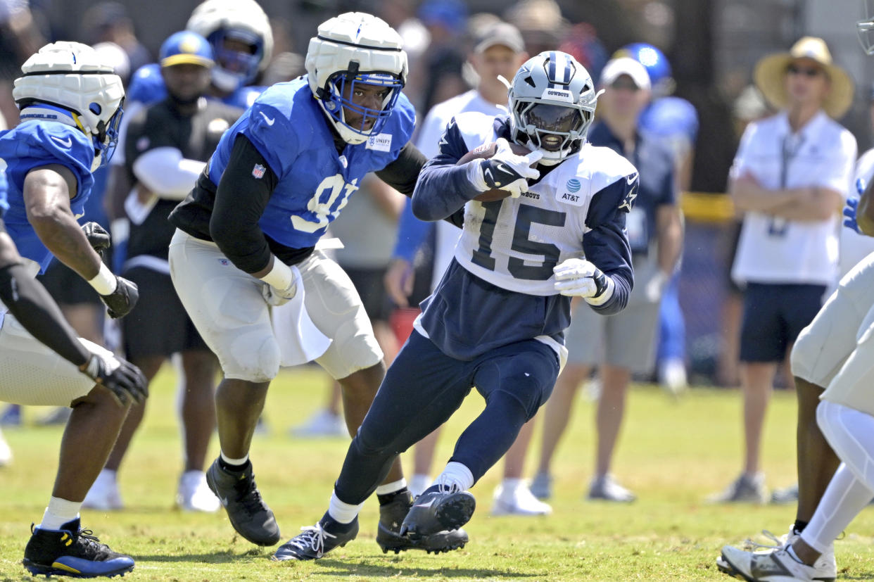 Dallas Cowboys running back Ezekiel Elliott (15) gets past Los Angeles Rams defensive tackle Kobie Turner during a joint practice at NFL football training camp Thursday, Aug. 8, 2024, in Oxnard, Calif. (AP Photo/Jayne Kamin-Oncea)