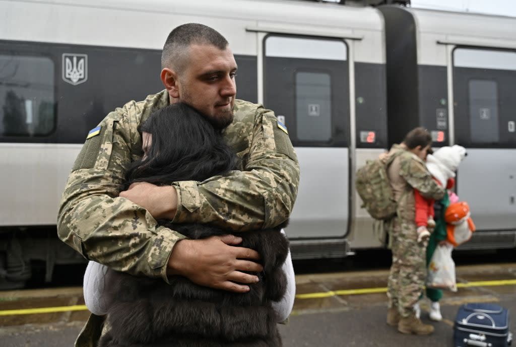 29-year-old Ukrainian servicemen Dmytro embraces his wife before she boards a train heading to Kyiv at a railway station in the Donetsk region, on Sunday October 8 (AFP via Getty Images)