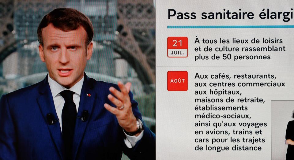 French President Emmanuel Macron is seen on a TV screen as he speaks during a televised address to the nation from the temporary Grand Palais in Paris on July 12, 2021. - Macron announced  mandatory Covid jabs for healthcare staff and that 'Covid pass' will be needed in restaurants from August. (Photo by Ludovic MARIN / AFP) (Photo by LUDOVIC MARIN/AFP via Getty Images)