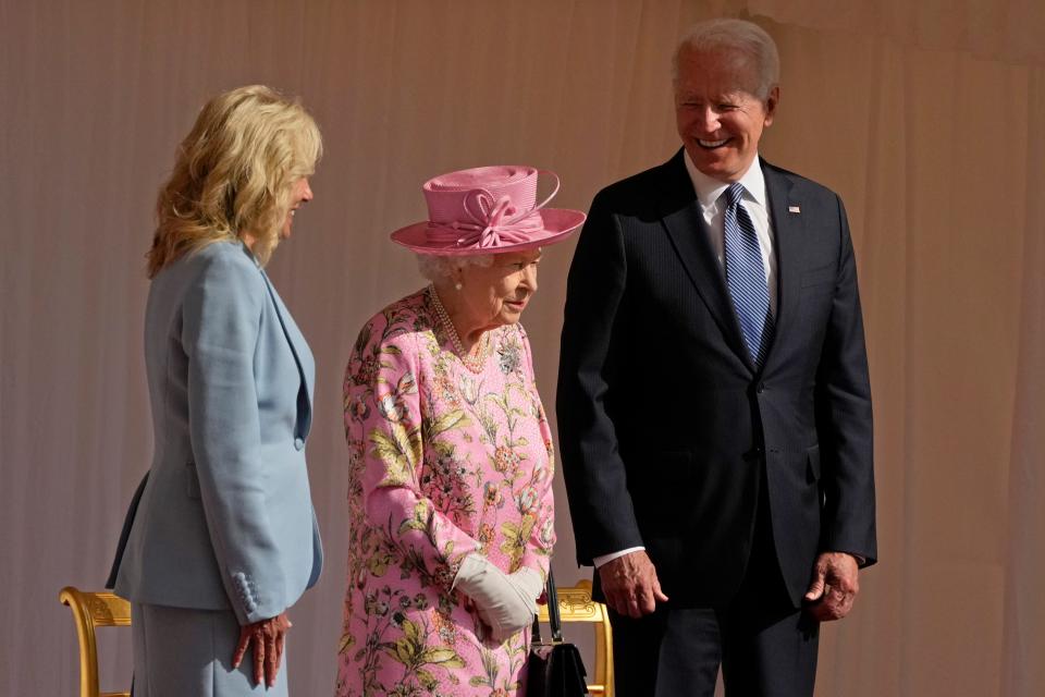 President Joe Biden and first lady Jill Biden smile while standing with Britain's Queen Elizabeth II watching a Guard of Honour march past before their meeting at Windsor Castle near London, June 13, 2021. Queen Elizabeth II, Britain's longest-reigning monarch and a rock of stability across much of a turbulent century, died Thursday, Sept. 8, 2022, after 70 years on the throne. She was 96.