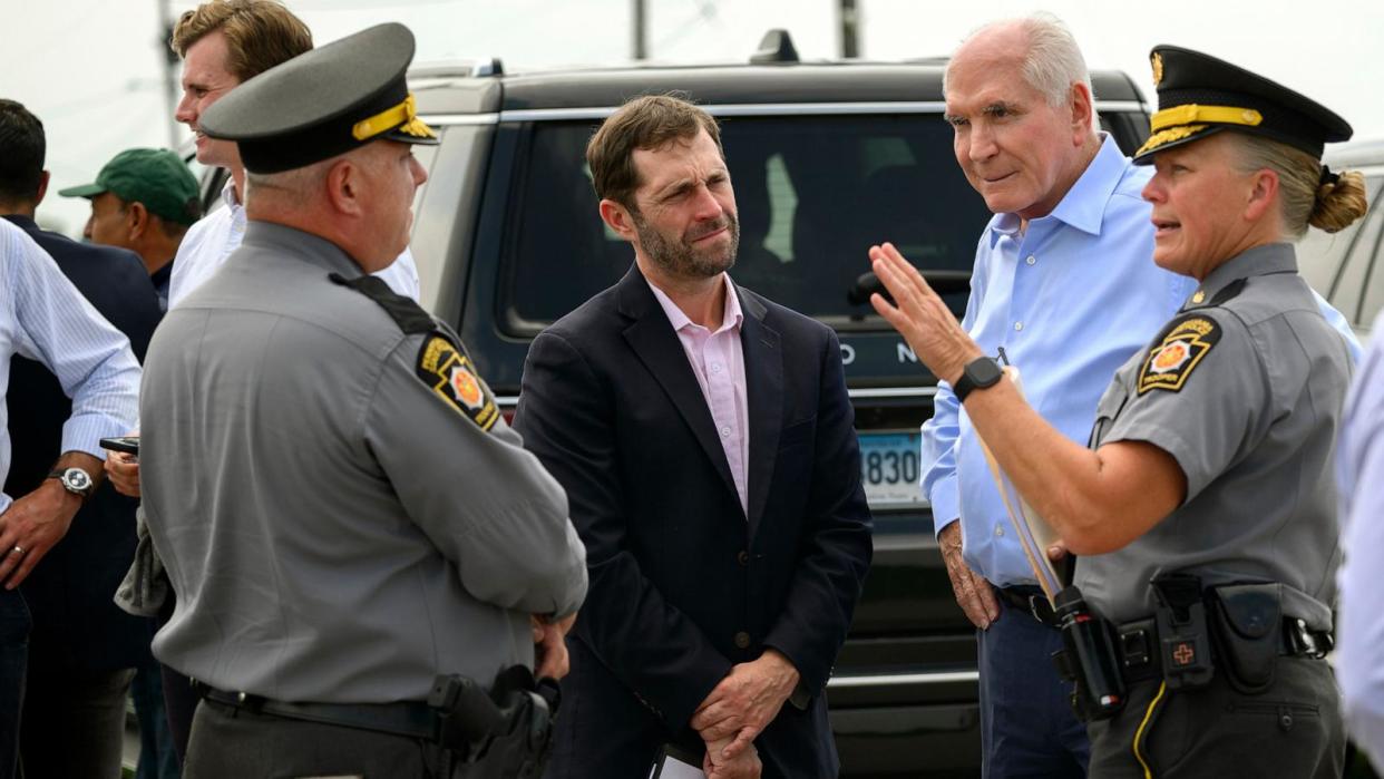 PHOTO: Rep. Jason Crow and Rep. Mike Kelly discuss plans with Pennsylvania State Troopers to tour of the shooting site at the Butler Farm Show Grounds, on Aug. 26, 2024, in Butler, Pennsylvania. (Jeff Swensen/Getty Images)