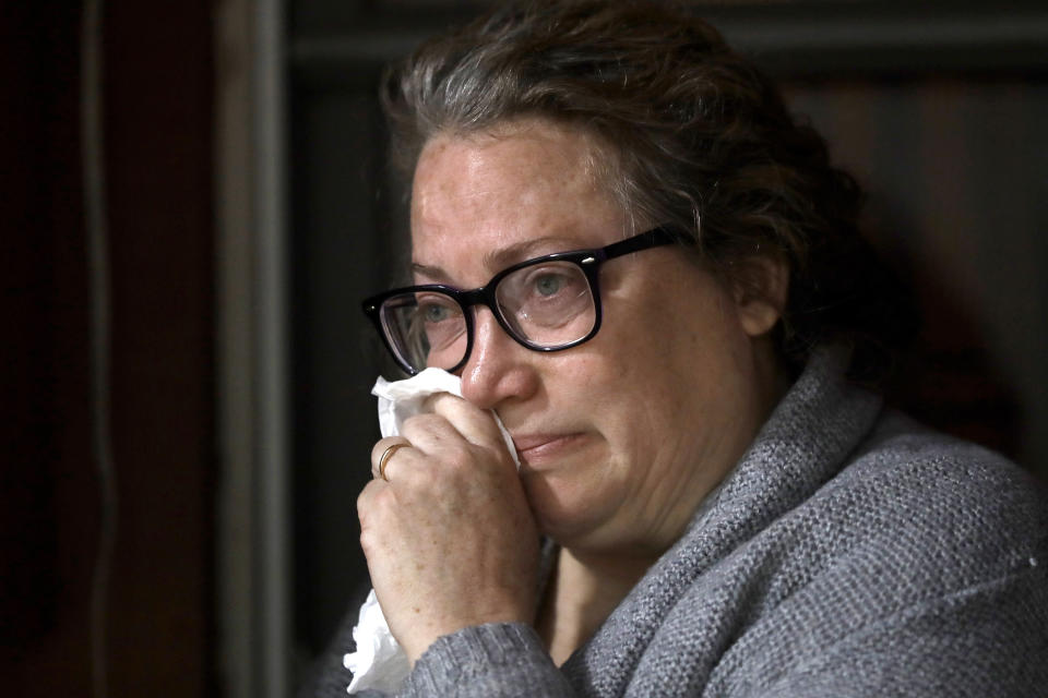 Susan Kenney, of Ware, Mass., who lost her father to the coronavirus, is tearful while speaking to a reporter from The Associated Press on the front porch of her home, Thursday, April 30, 2020, in Ware. Her father, Air Force veteran Charles Lowell, was a resident at the state-run Holyoke Soldiers' Home. While the death toll at the state-run Holyoke Soldiers' Home continues to climb, federal officials are investigating whether residents were denied proper medical care and the state's top prosecutor is deciding whether to bring legal action. (AP Photo/Steven Senne)