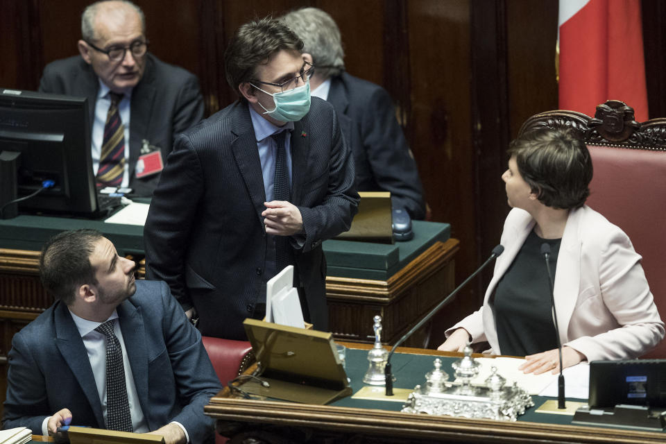 Lawmaker Matteo Dall'Osso wears a sanitary mask during a work session in the Italian lower chamber Tuesday, Feb. 25, 2020. Civil protection officials on Tuesday reported a large jump of cases in Italy, from 222 to 283. Seven people have died, all of them elderly people suffering other pathologies. (Roberto Monaldo/LaPresse via AP)