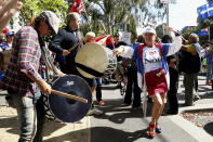 A protester and fan of Serbia's Novak Djokovic dances outside the Park Hotel, used as an immigration detention hotel where Djokovic is confined in Melbourne, Australia, Saturday, Jan. 8, 2022. He has been confined to the detention hotel in Melbourne pending a court hearing on Monday, a week before the start of the Australian Open. Djokovic was barred from entering the country late Wednesday when federal border authorities at the Melbourne airport rejected his medical exemption to Australia's strict COVID-19 vaccination requirements. (AP Photo/Hamish Blair)