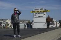 Passersby look at the charred remains of the Mariner's Cove Inn in Point Pleasant Beach, New Jersey, March 21, 2014. REUTERS/Charles Mostoller