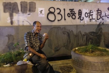 Lou Tit-Man, 73, eats dinner outside Mong Kok Police Station in Hong Kong