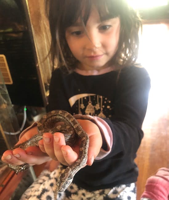Damiana, filha de Andrés, com pequenas cobras nas mãos