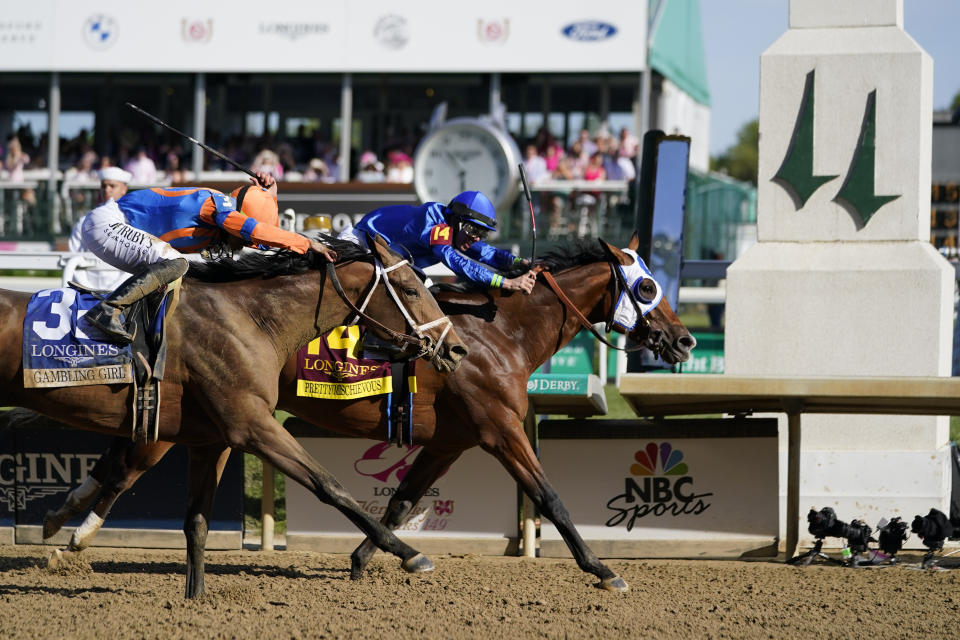 Pretty Mischievous (14), with Tyler Gaffalione aboard, past the finish line to win the 149th running of the Kentucky Oaks horse race at Churchill Downs Friday, May 5, 2023, in Louisville, Ky. (AP Photo/Kiichiro Sato)