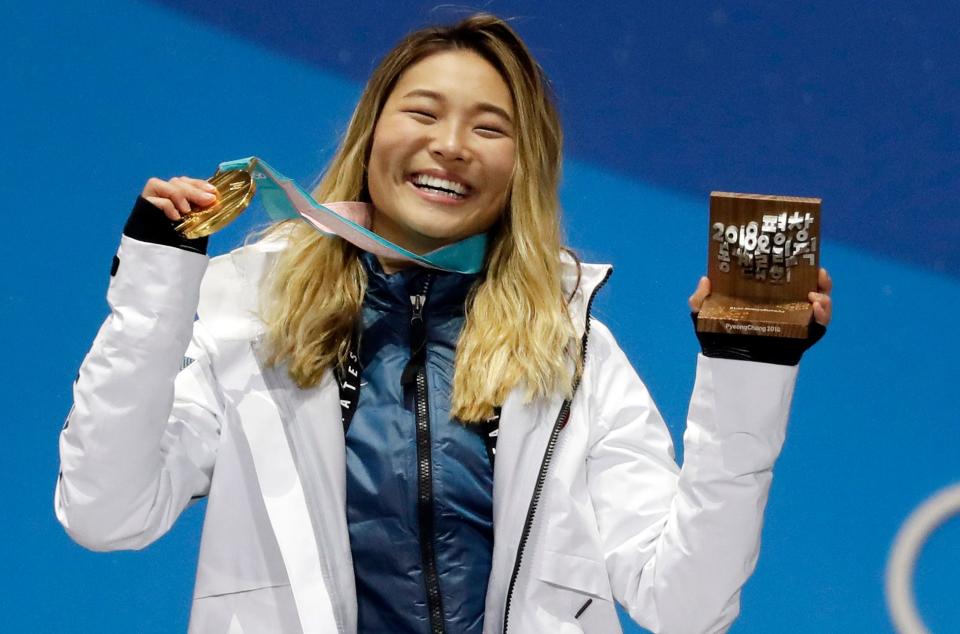 Chloe Kim poses with her Olympic gold medal from the 2018 games.