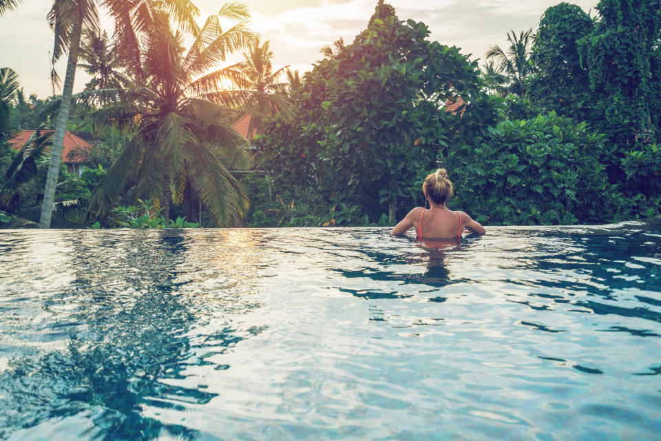 Young woman on the edge of an infinity pool, Ubud, Bali
People travel vacations concept.