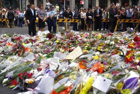 Australian Prime Minister Tony Abbott and his wife Margie stand after placing floral tributes amongst thousands of others near the Lindt cafe, where hostages were held for over 16-hours, in central Sydney December 16, 2014. REUTERS/David Gray