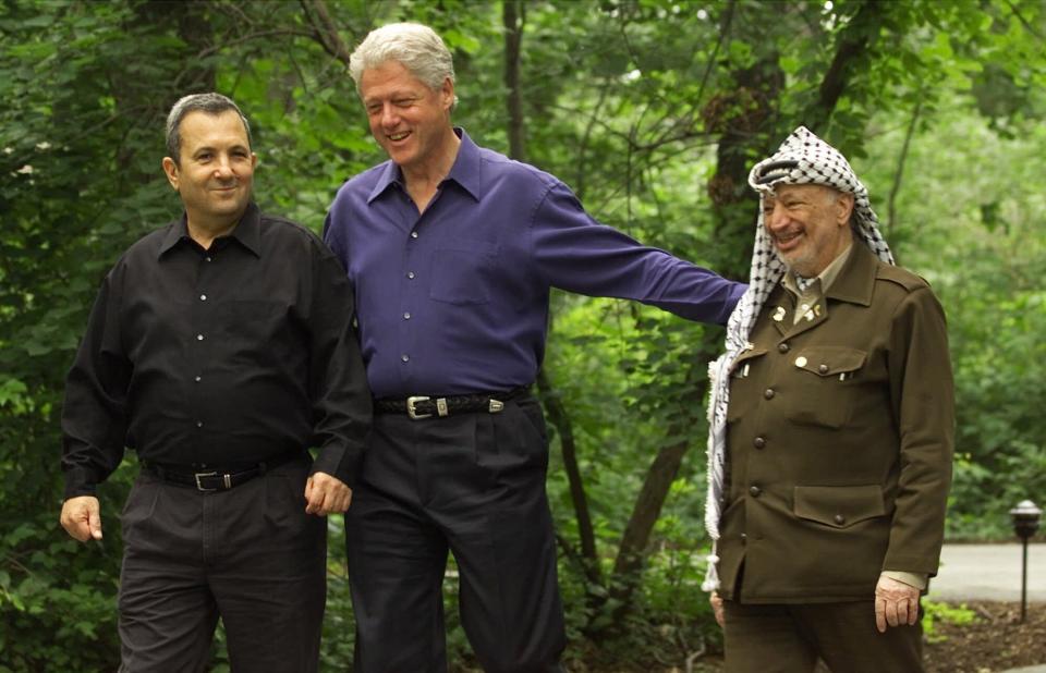 Then President Clinton, center, accompanied by Israeli Prime Minister Ehud Barak, left, and Palestinian leader Yasser Arafat, right, walk on the grounds of Camp David, Md. in this July 11, 2000 file photo, during a Mideast summit.