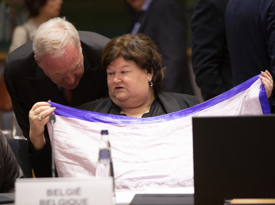 Belgian Health Minister Maggie De Block folds a scarf she received as a gift during an extraordinary meeting of EU health ministers in Brussels to discuss the Covid-19 virus outbreak, Friday, March 6, 2020. Fearing a possible shortage in medicine and protective masks, health ministers from the European Union are trying to boost their collective response to the novel coronavirus outbreak during an emergency meeting. (AP Photo/Virginia Mayo)