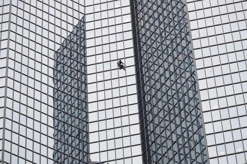 El escalador francés Alain Robert, también conocido como "hombre araña", escala el rascacielos del Tour Total en apoyo a los huelguistas de la reforma de las pensiones en el distrito financiero y de negocios de La Defense, cerca de París, Francia, el 13 de enero de 2020