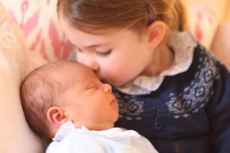 Princess Charlotte cradling new born Prince Louis on her third birthday -Credit: Duchess of Cambridge/PA Wire