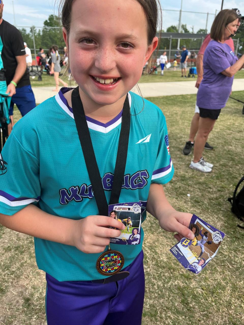 Jolie Normand poses with her LSU trading cards during a softball tournament with the 10U Mudbugs team. (Photo courtesy of Leslie and Mark Normand).